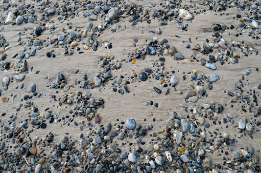 Polished stones tucked in the flowing silk of the riverbed, with smooth, silky textures creating a serene and tranquil scene.